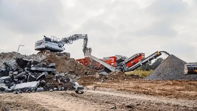 Kettenbagger an der Brechanlage im Bauschutt